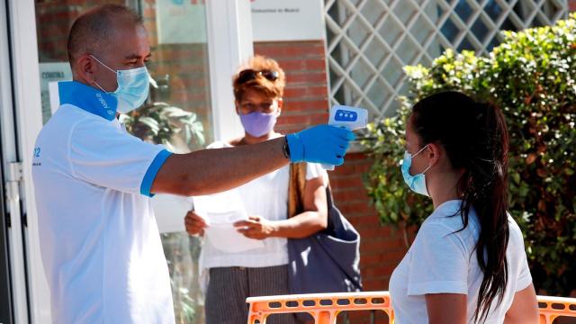 Un sanitario toma la temperatura a una joven en San Sebastián de los Reyes, Madrid. EFE/Zipi