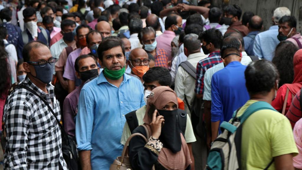 La gente guarda cola para coger un autobús en la ciudad de Bombay.