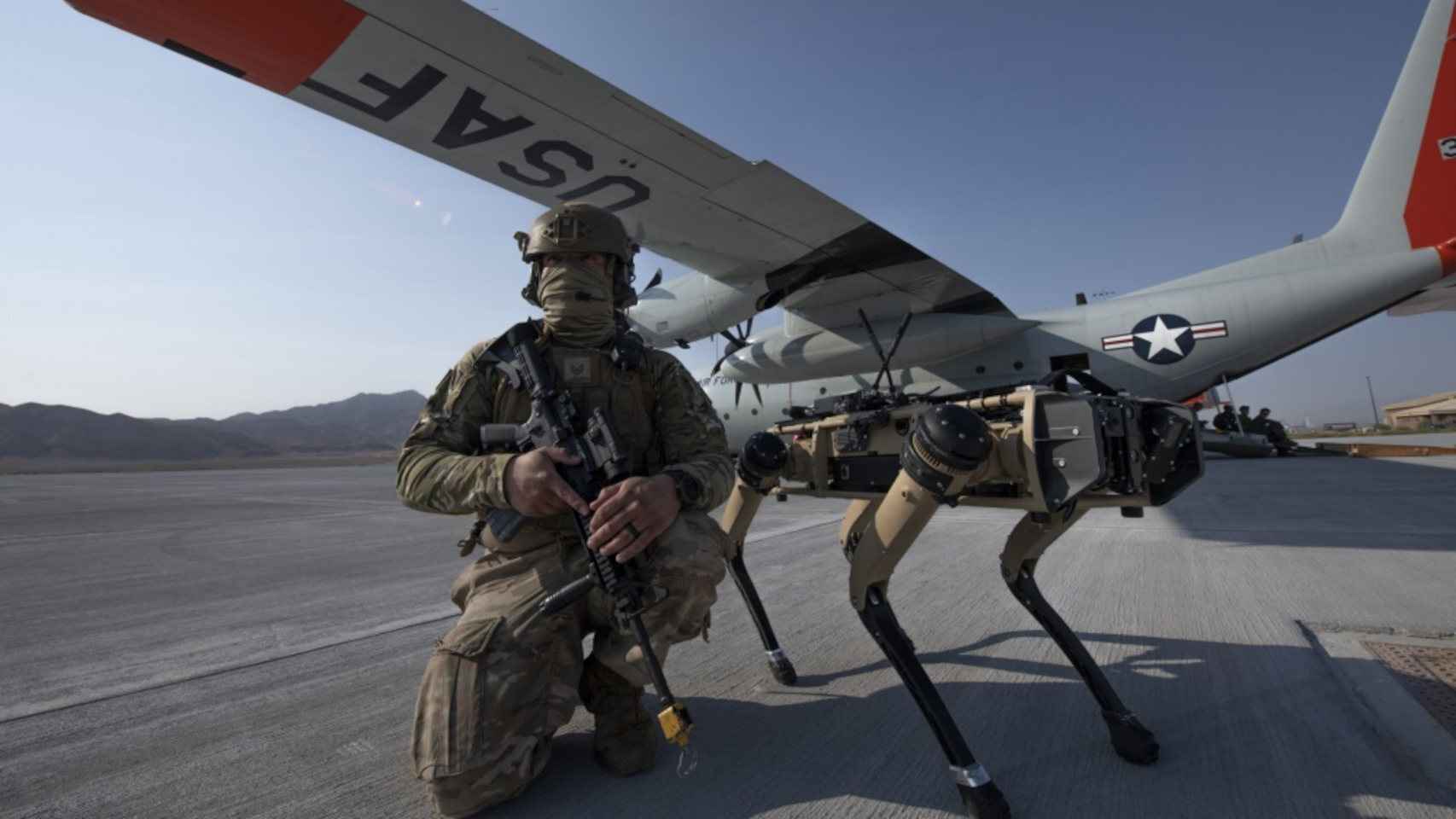 Un soldado estadounidense posa con un perro robótico
