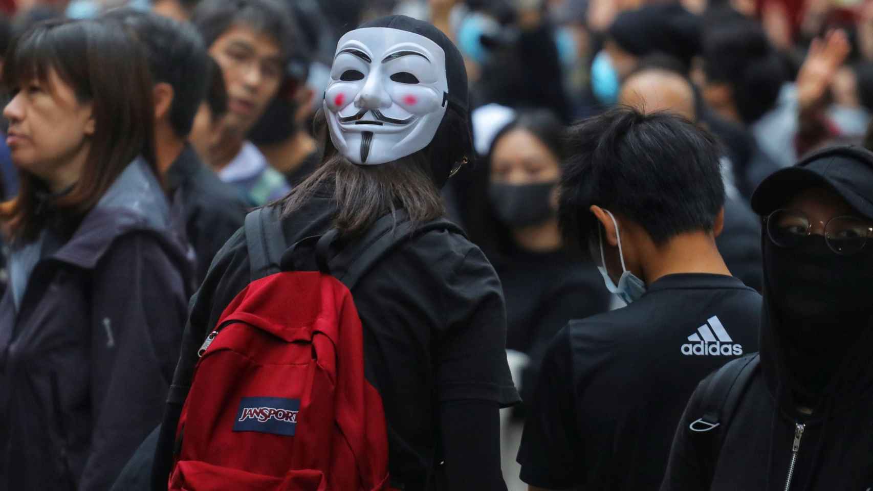 Una manifestante con máscara.