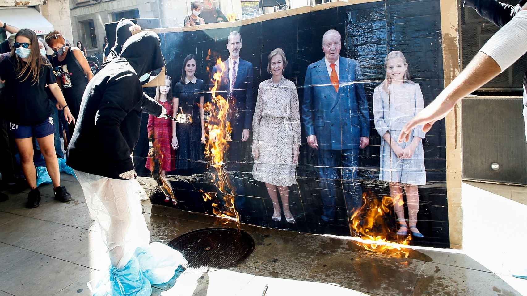 Varios jóvenes queman un retrato de la familia real durante la manifestación convocada por la organización Arran.