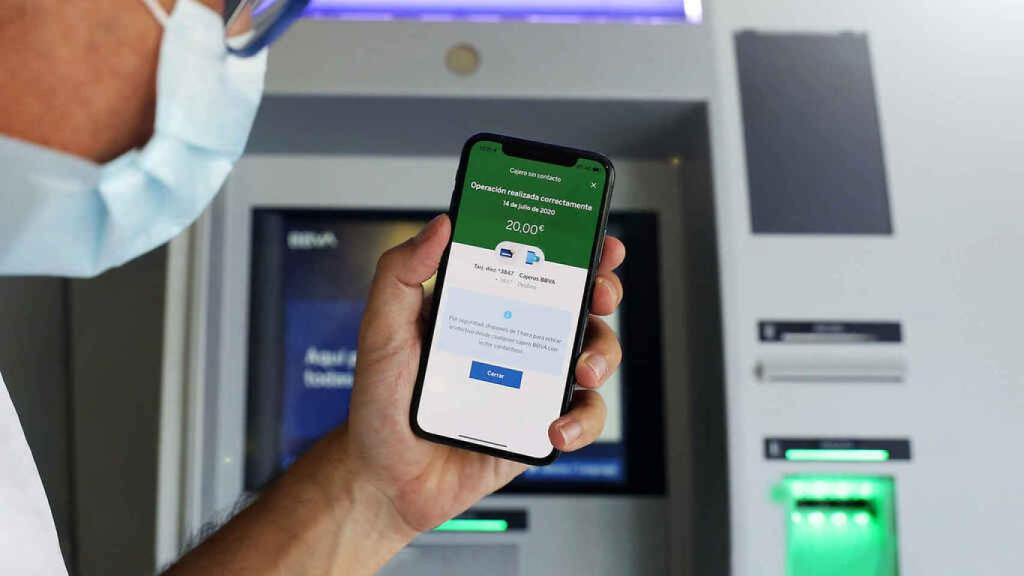 Un cliente saca efectivo sin contacto en un cajero.
