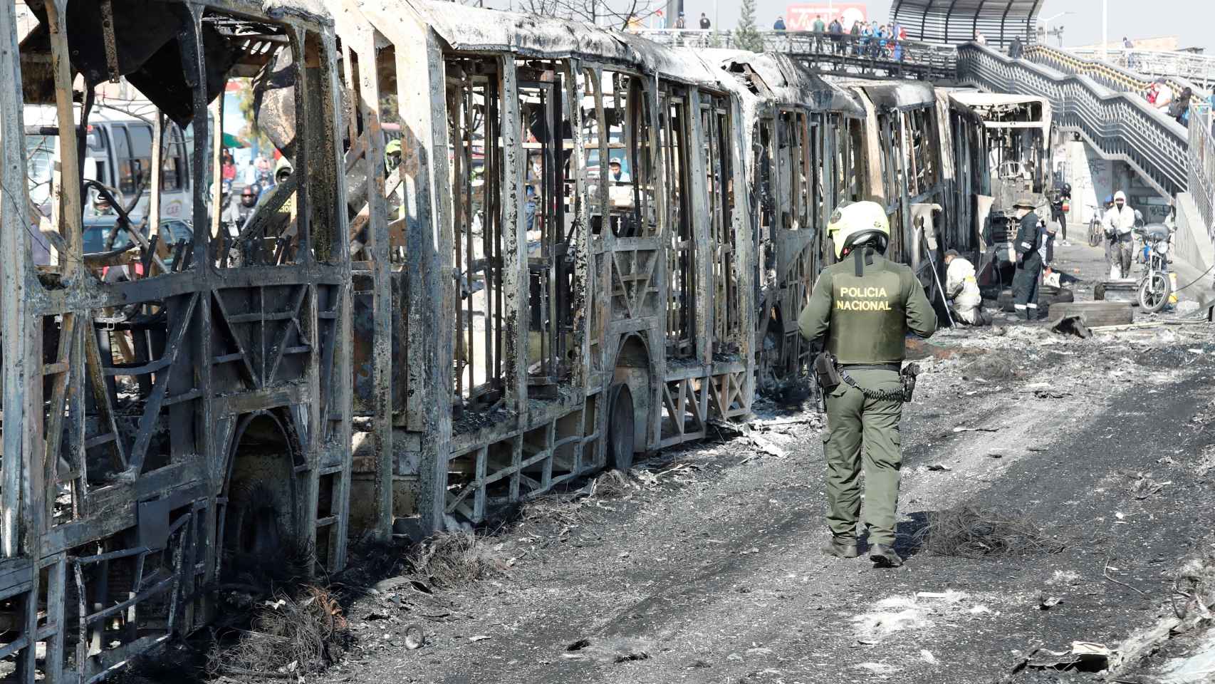 Un policía observa los restos incinerados de un autobús en la localidad de Bosa, en Bogotá.