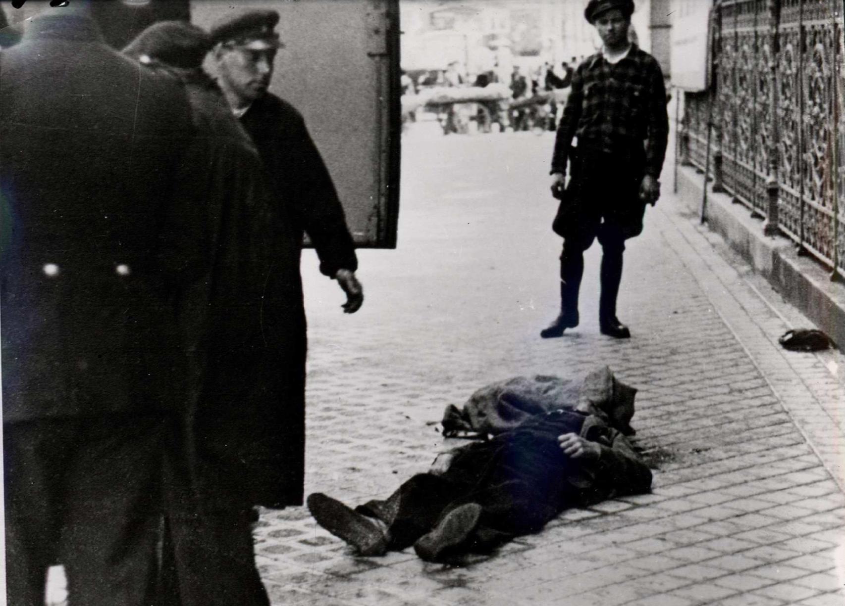 Una persona muerta durante un bombardeo franquista yace delante de la verja del Banco de España.