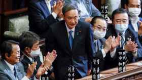 Yoshihide Suga, aplaudido por sus compañeros de partido tras ser elegido primer ministro.