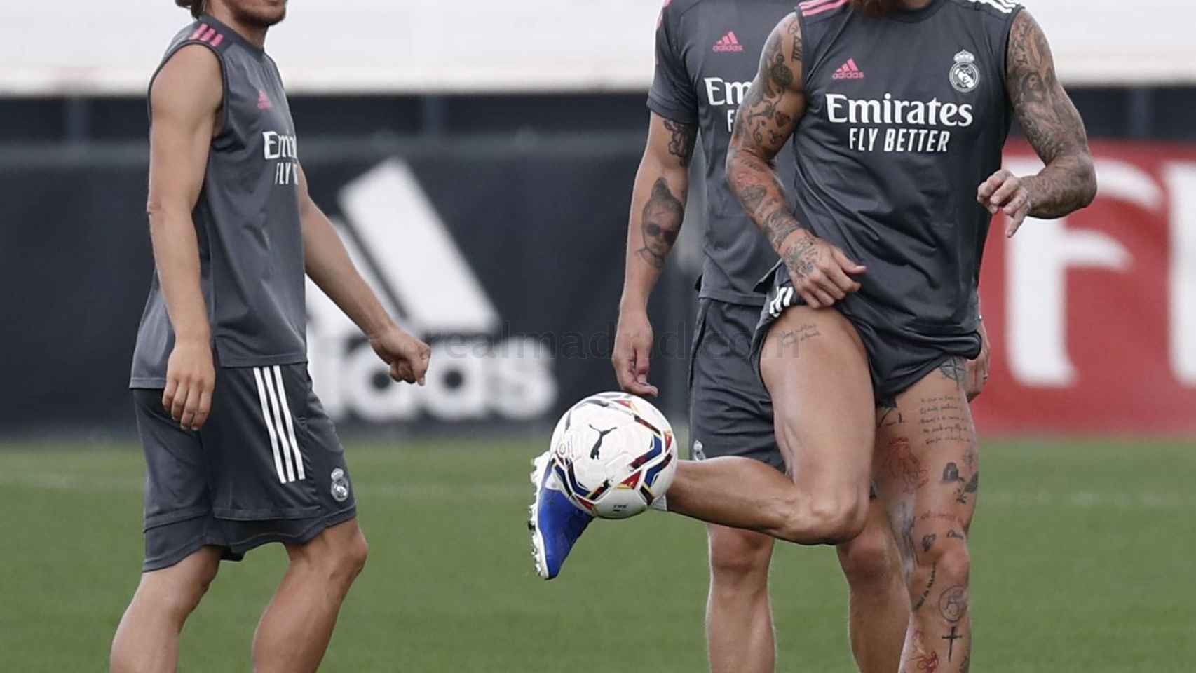 Sergio Ramos tocando el balón durante un entrenamiento junto a Modric y Kroos