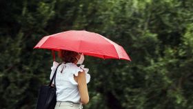 Una mujer se protege de la lluvia con un paraguas en Valencia.
