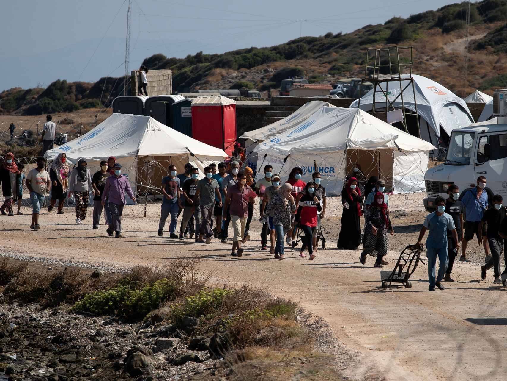 Los refugiados del campo de moria entrando en un campo provisional tras el incendio.