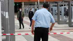 Un vigilante de seguridad conversa con un hombre y una mujer este sábado en Alcobendas.