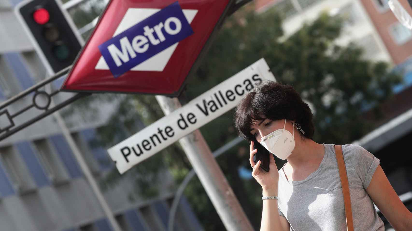 Una mujer pasea al lado del metro de Puente de Vallecas, en Madrid (España).