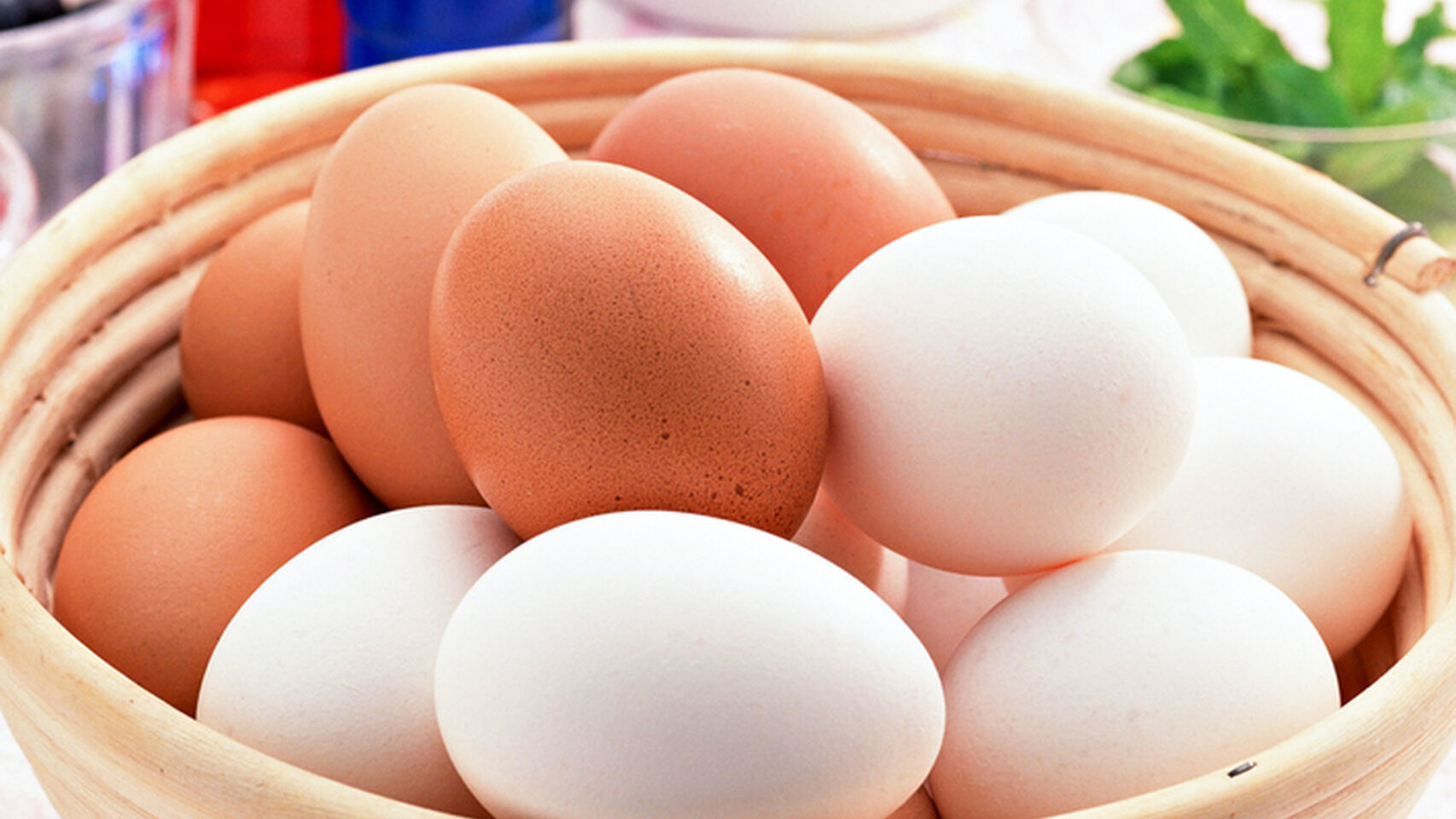 Una cesta de huevos morenos y blancos.