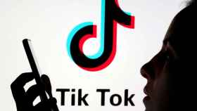 FILE PHOTO: A person holds a smartphone as Tik Tok logo is displayed behind in this picture illustration
