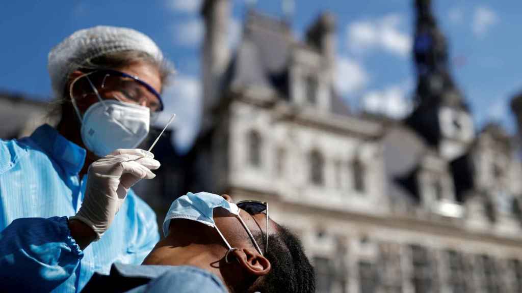Un sanitario hace una PCR frente al Ayuntamiento de París