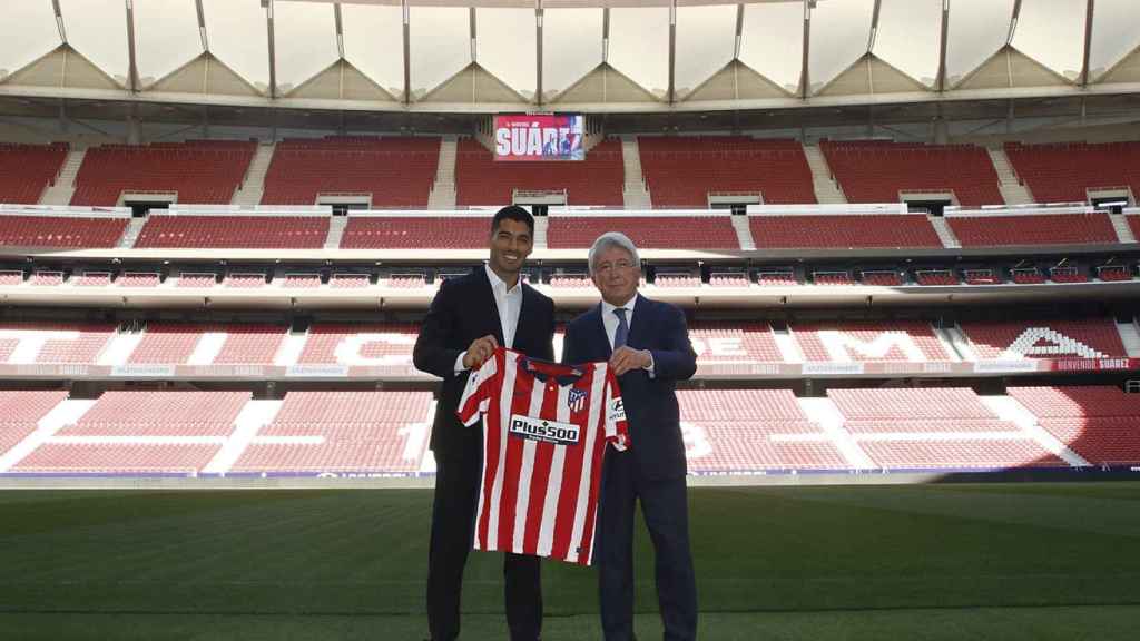 Luis Suárez y Enrique Cerezo posan con la camiseta del Atlético de Madrid