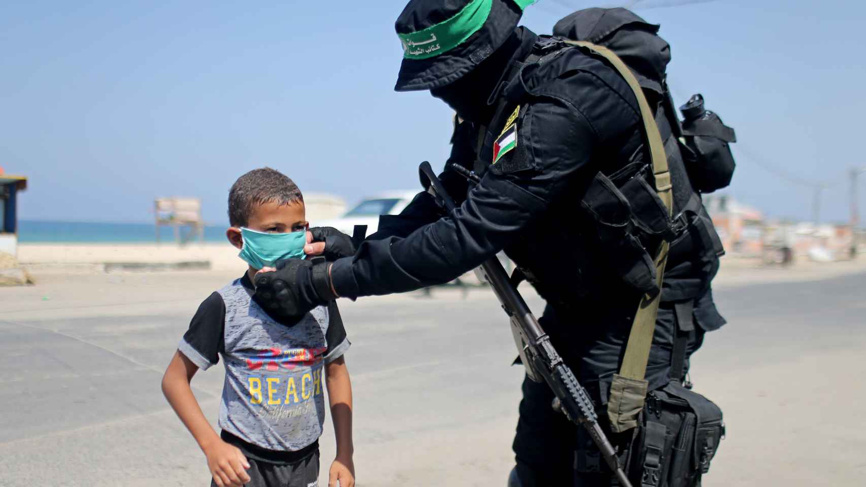 Un militante de Hamás coloca una mascarilla a un niño en Gaza.