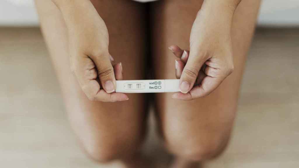 Una mujer sostiene un test de embarazo.