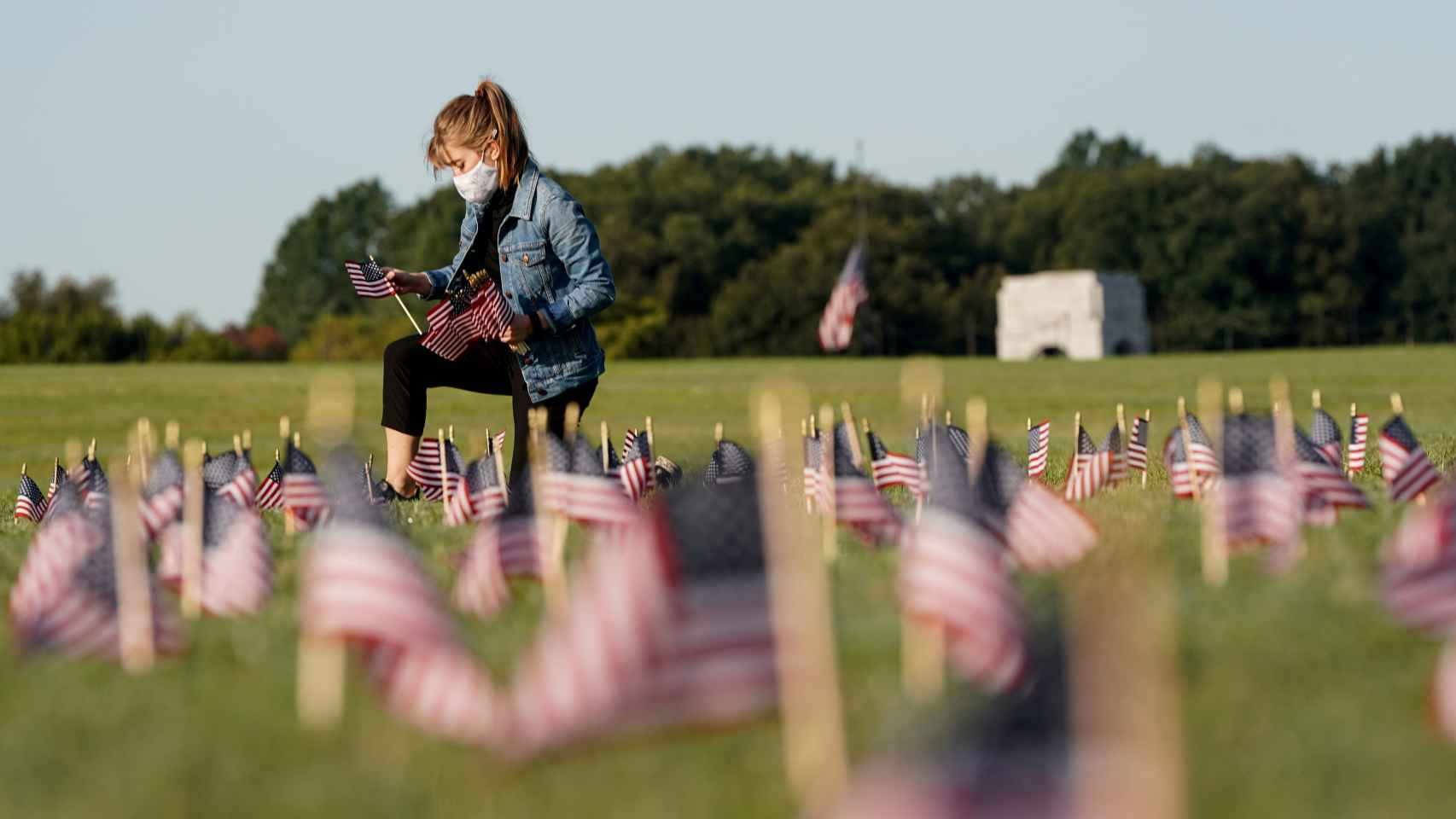 En Washington, una joven coloca banderas por cada una de las más de 200.000 víctimas de la Covid-19 en EEUU.