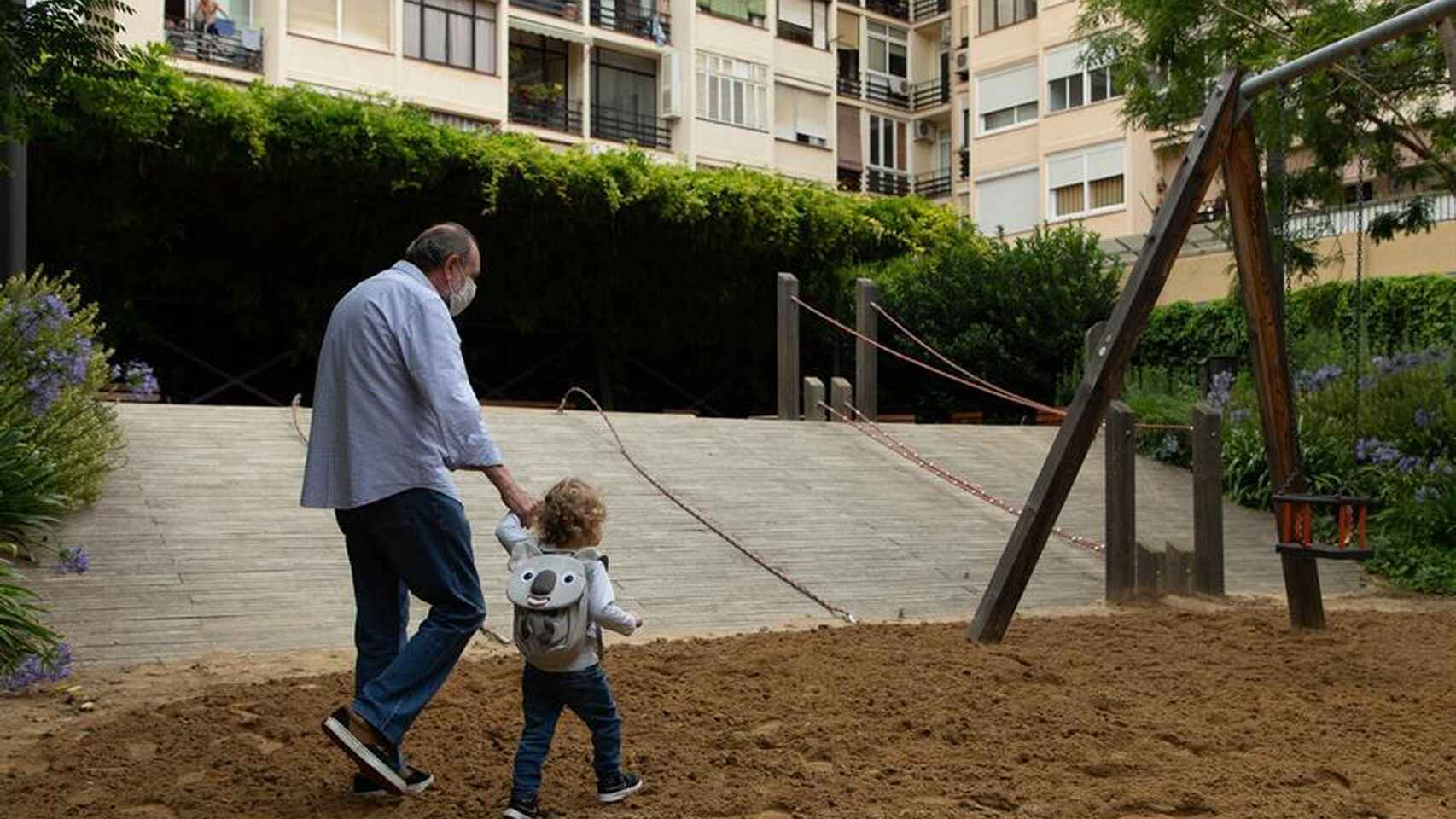 Un abuelo lleva a su nieta al parque en la anterior reapertura en Madrid.
