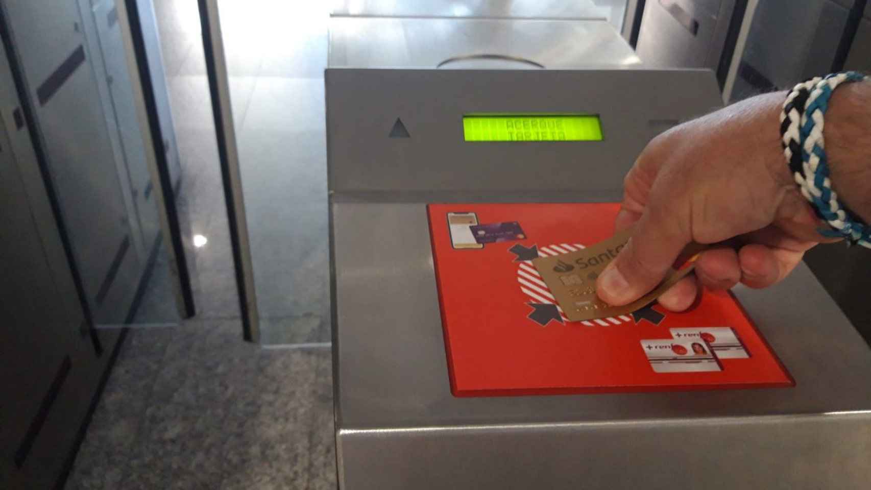 Un usuario paga el trayecto de Cercanías de Renfe con una tarjeta bancaria