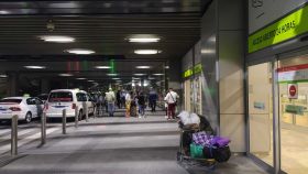 Escasos viajeros esperan en la puerta de la T-1 de Barajas su vuelo.