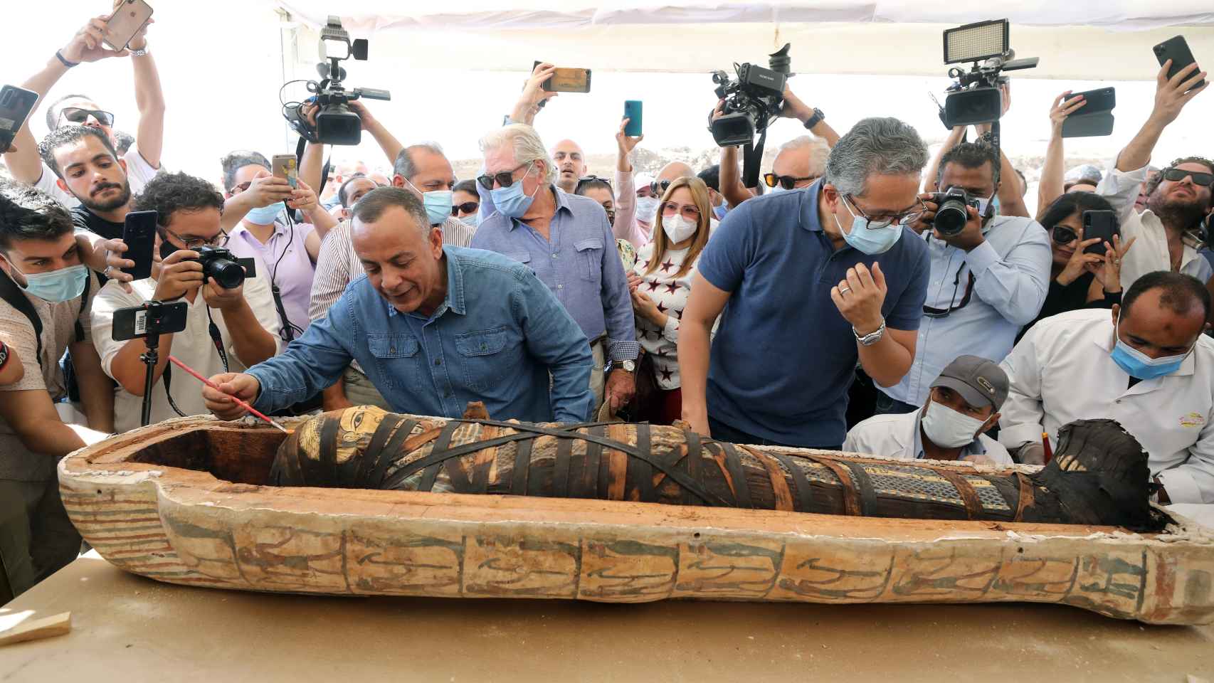 Mostafa Waziri, secretario general del Consejo Supremo de Antigüedades, y Khaled El-Enany, ministro de Antigüedades, abriendo uno de los sarcófagos.