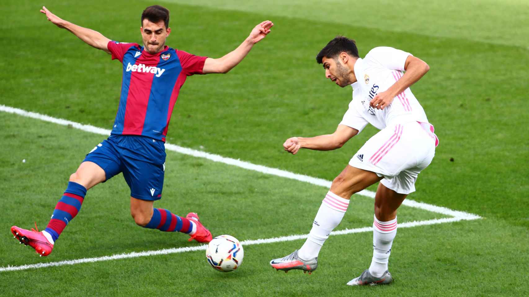 Marco Asensio dispara a la portería del Levante con un defensa delante