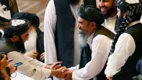 Los delegados talibanes se dan la mano durante las conversaciones.