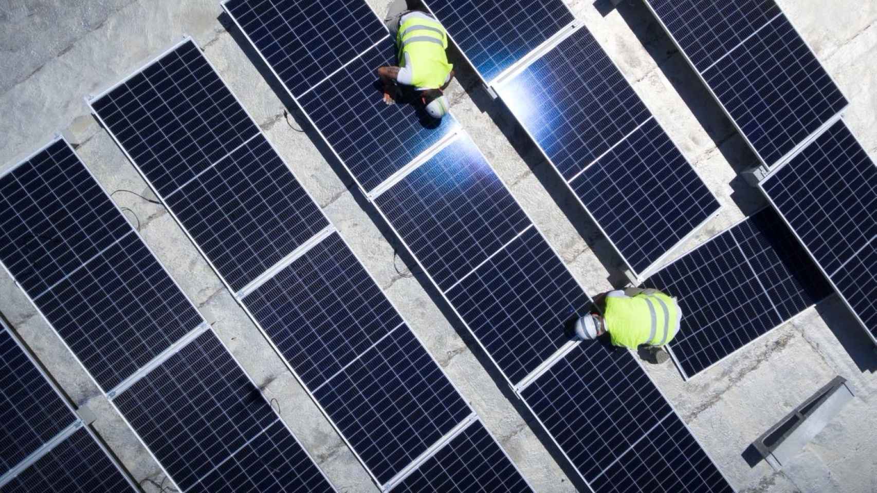 Unos operarios supervisan las instalaciones de un parque solar.