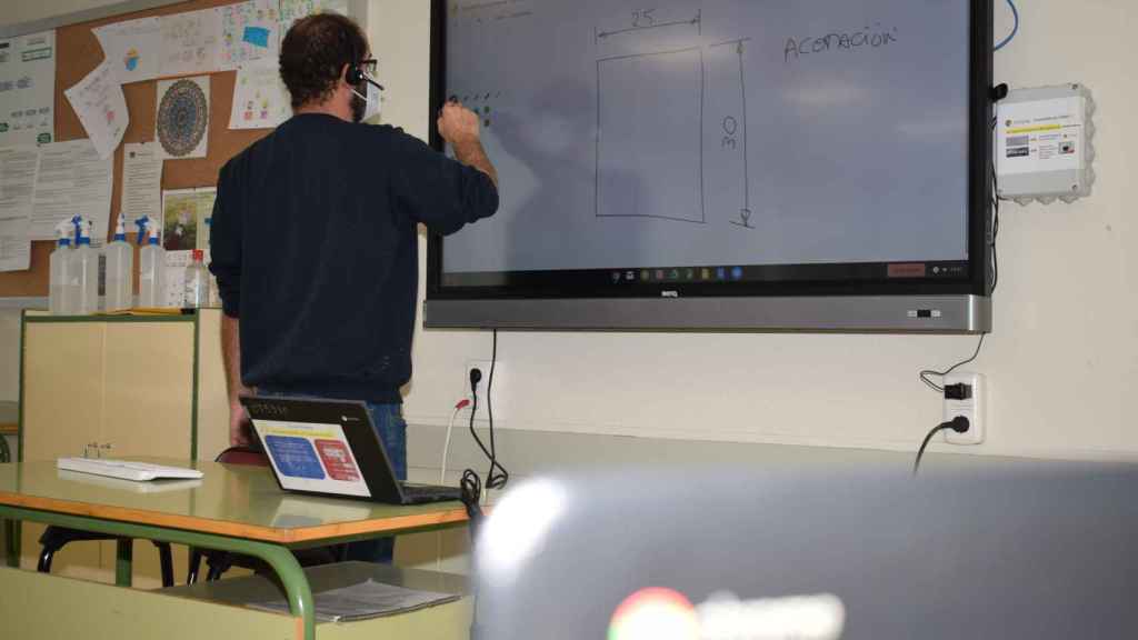 Un profesor con una pizarra digital.