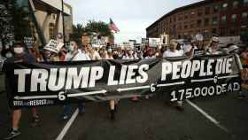 Personas marchan a la vigilia por las víctimas de la pandemia de coronavirus en Brooklyn, en agosto, con una pancarta que dice Trump miente, la gente muere.