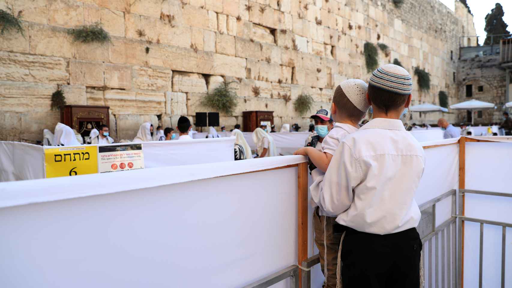 Dos niños miran a los fieles judíos en el Muro de las Lamentaciones.