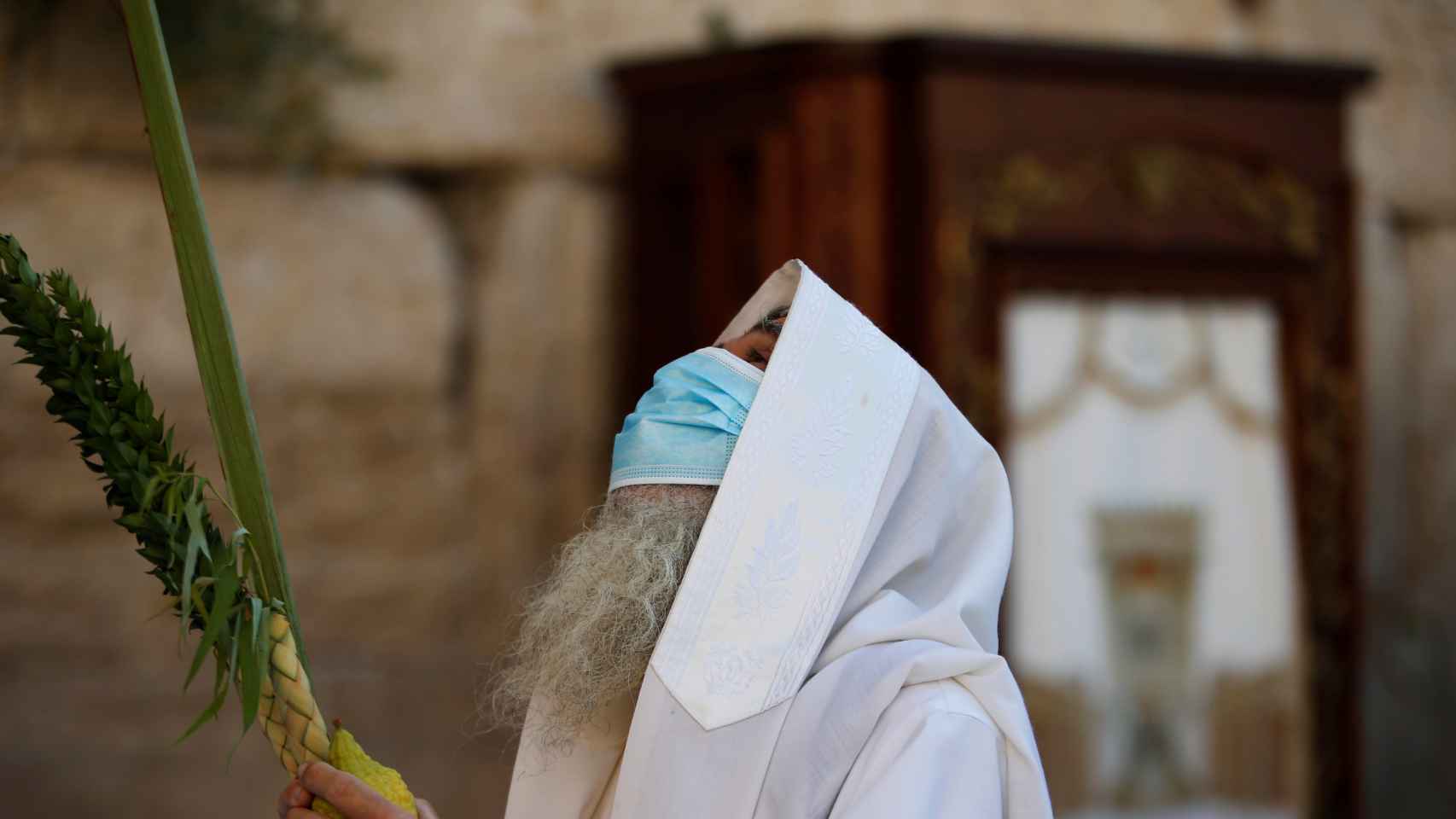 Un judío, con una máscara, en los rituales de la festividad de Sucot.