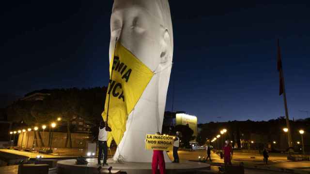 Greenpeace han colocado una mascarilla gigante (4x5 metros) en una escultura de la plaza de Colón (Madrid).
