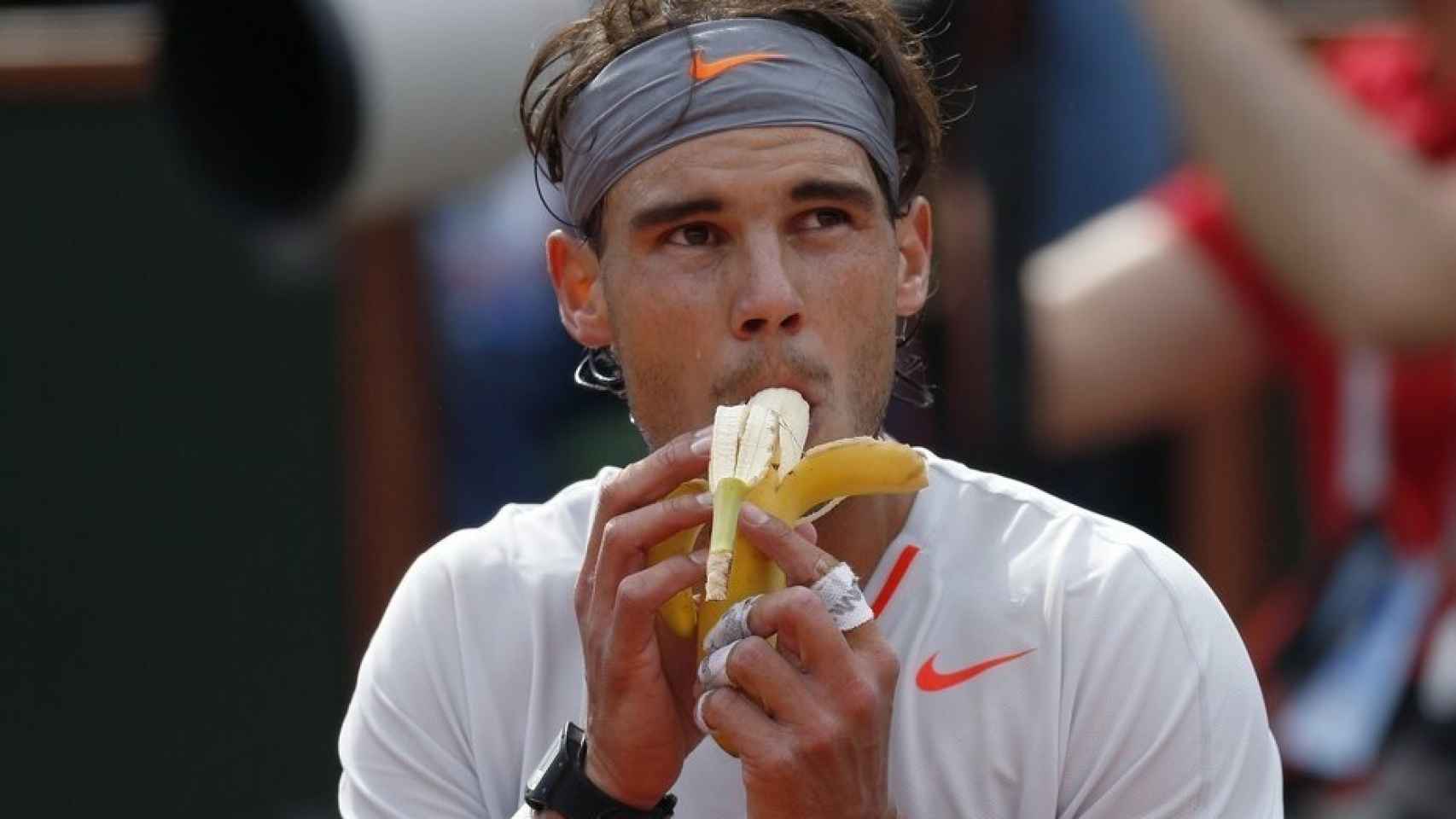 Rafa Nadal dándole un bocado a un plátano durante el descanso de un partido.