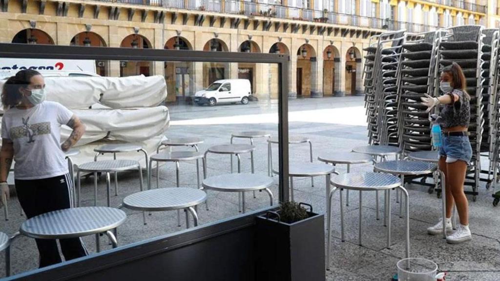 Empleadas de un bar de Cataluña preparan una terraza.