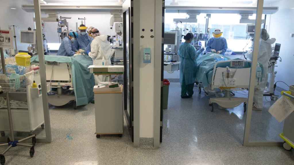 A la izda. Los médicos realizan una traqueotomía al paciente. A la dcha, preparan a otro para instalarle un 'pulmón artificial'.