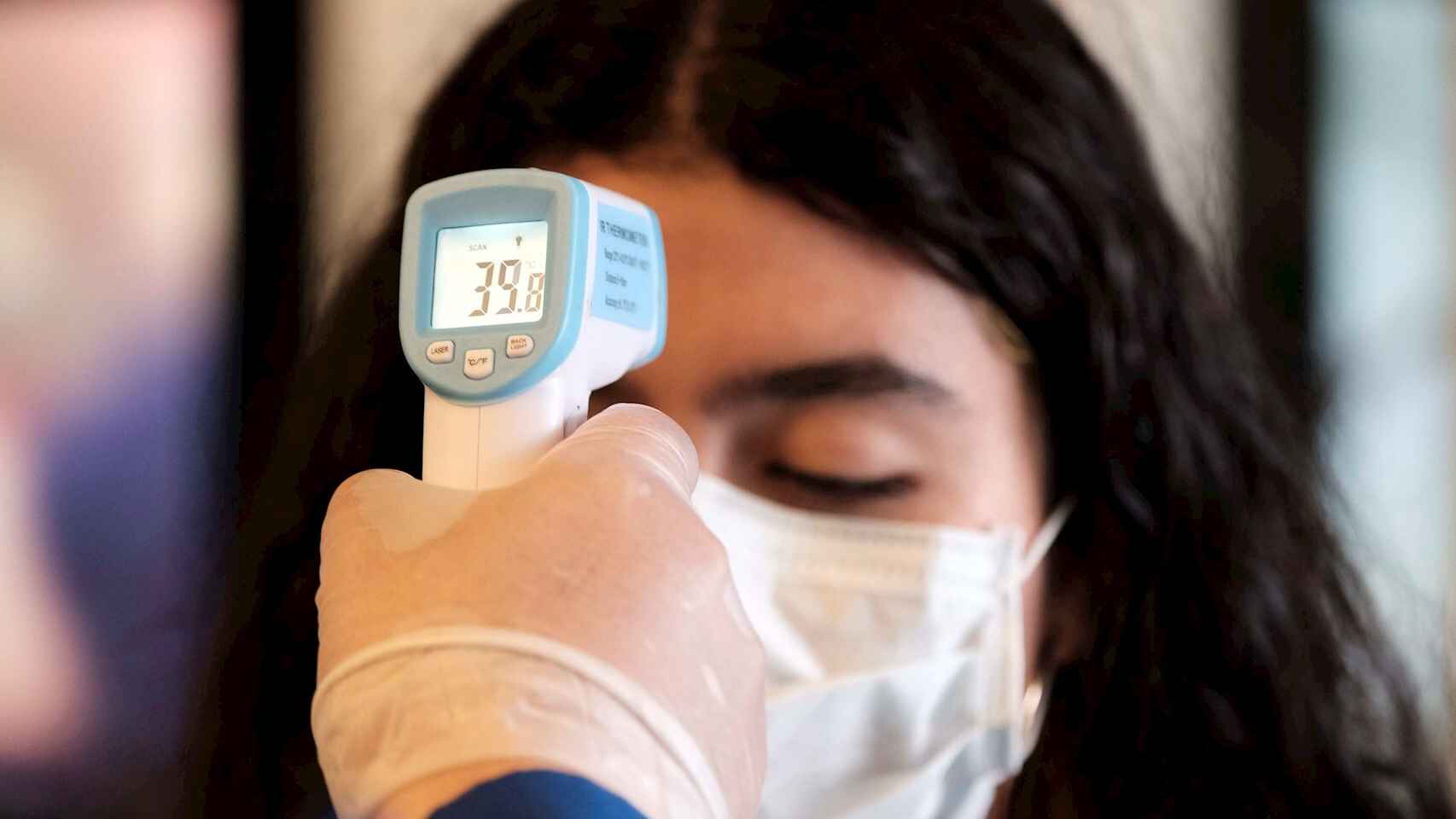 Personal sanitario mide la temperatura corporal de una mujer. EFE/Jeffrey Arguedas