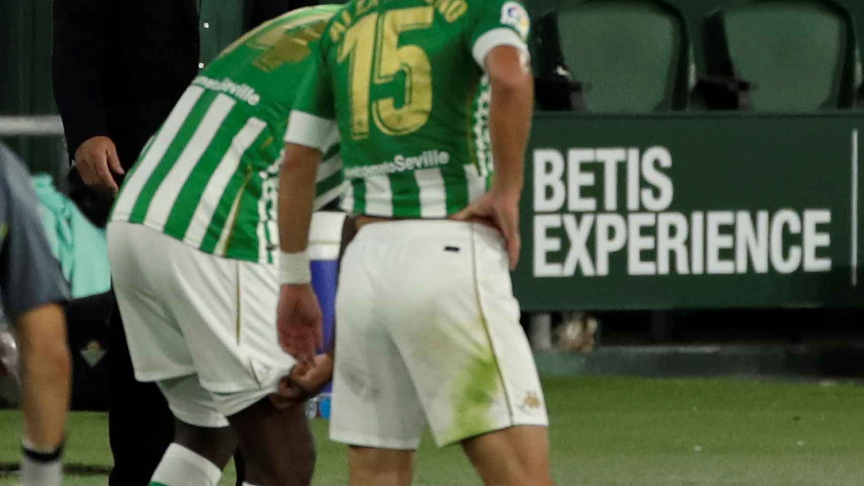 Pellegrini, de fondo con dos jugadores del Real Betis