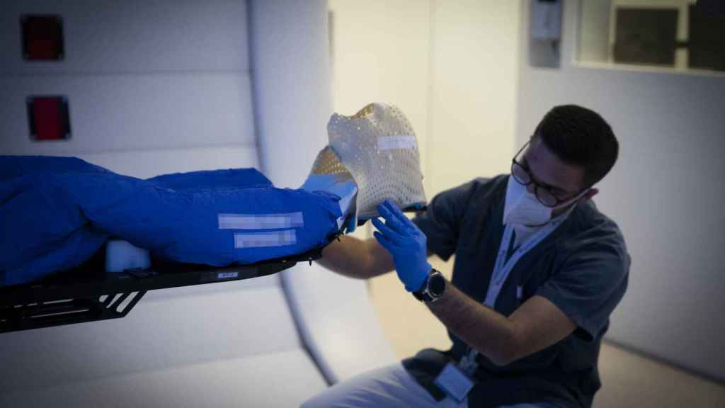 Un enfermero coloca el gorro que utilizan los enfermos en la sala de radiaciones.
