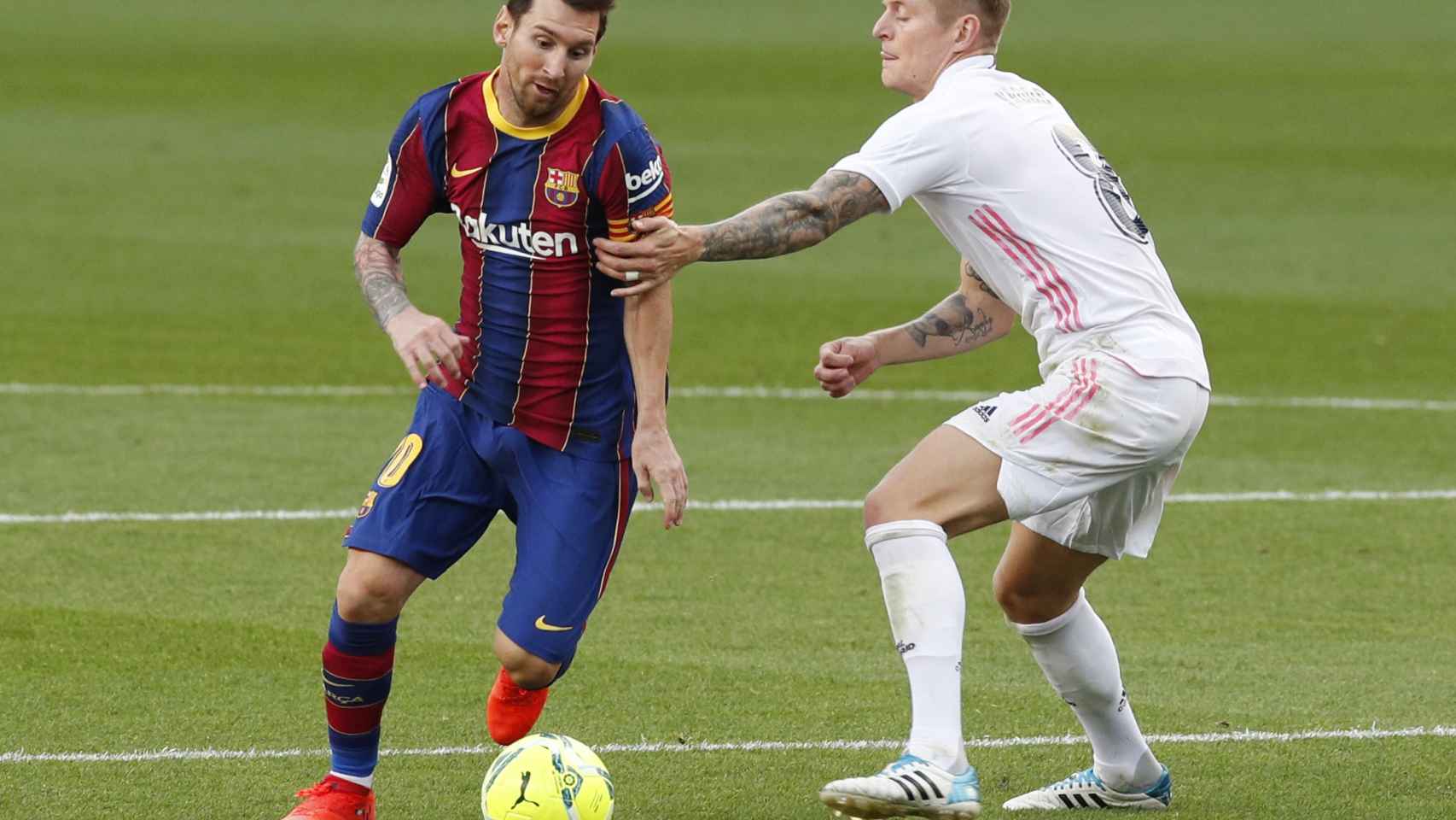Toni Kroos y Leo Messi luchan por la posesión en El Clásico de La Liga