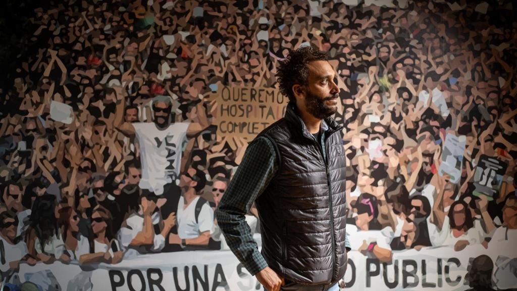 El médico granadino Jesús Candel, más conocido como Spiriman, ante un vinilo con una imagen de las manifestaciones multitudinarias que organizó contra la gestión de la sanidad pública andaluza.