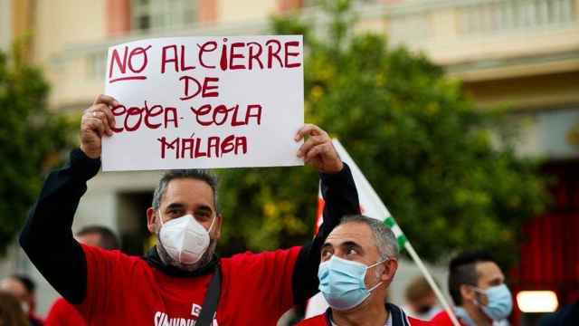 Un trabajador con una pancarta en la concentración contra el cierre de la planta de Coca-Cola en Málaga.