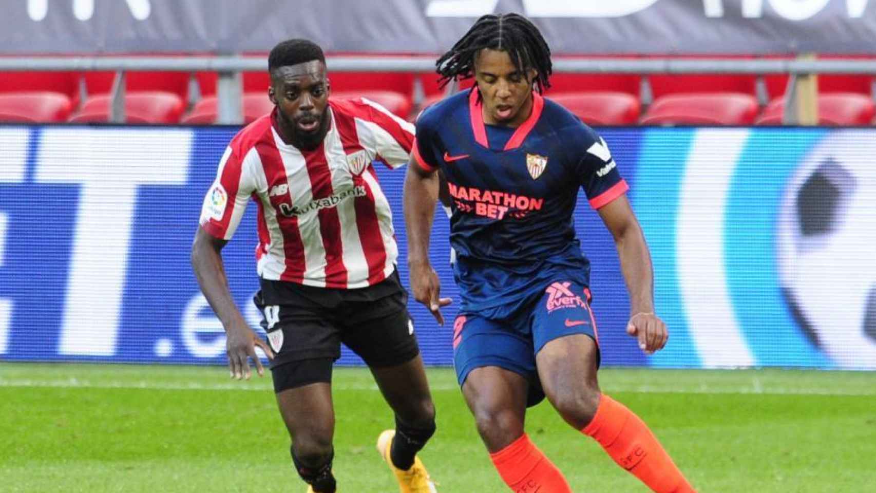 Jules Koundé protege el balón ante Iñaki Williams, en el Athletic - Sevilla de La Liga