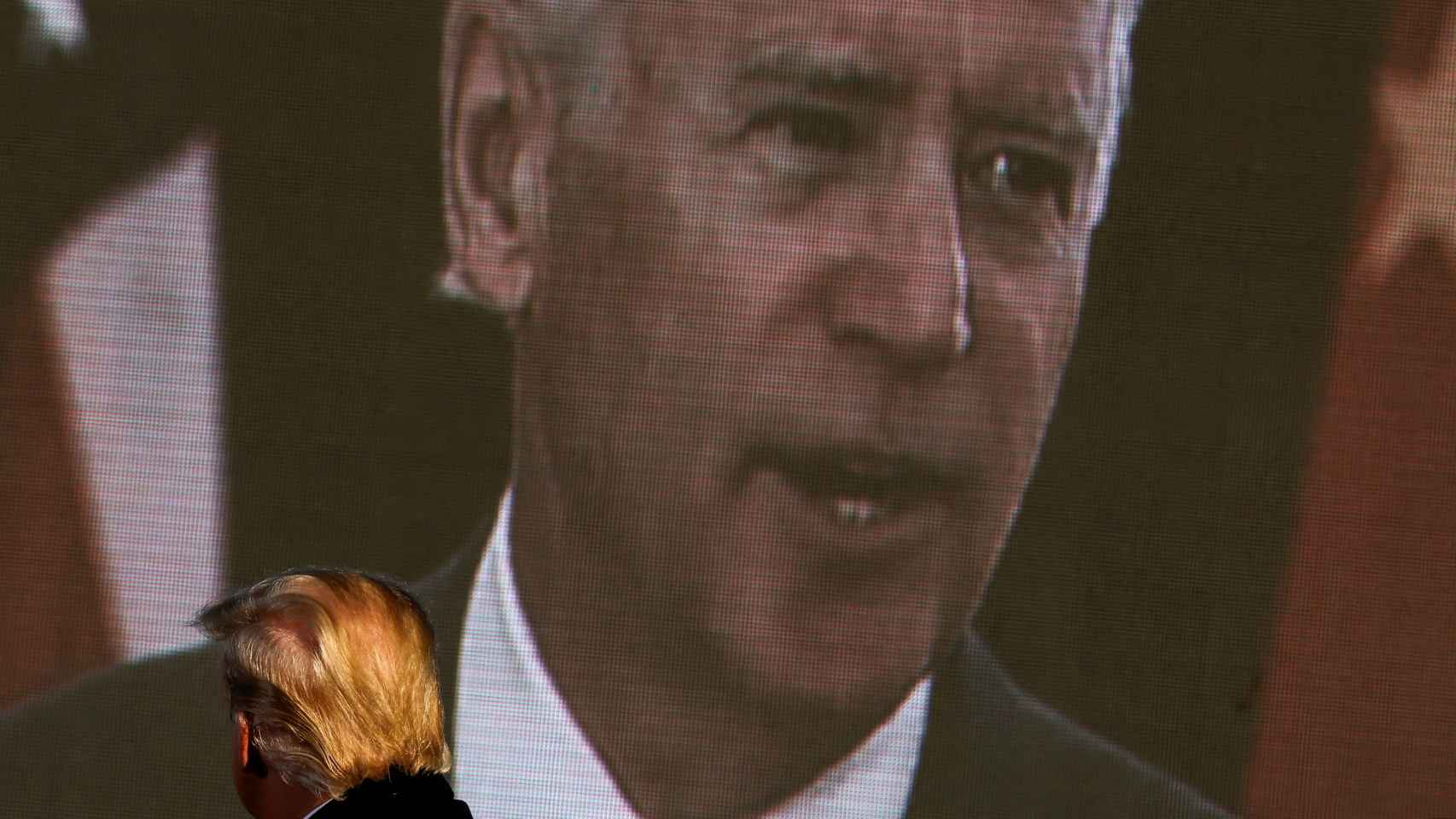 Donald Trump observando una imagen de Joe Biden.