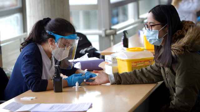 Una estudiante de Enfermería realiza un test rápido a una alumna en el campus de la Universidad de Vigo.