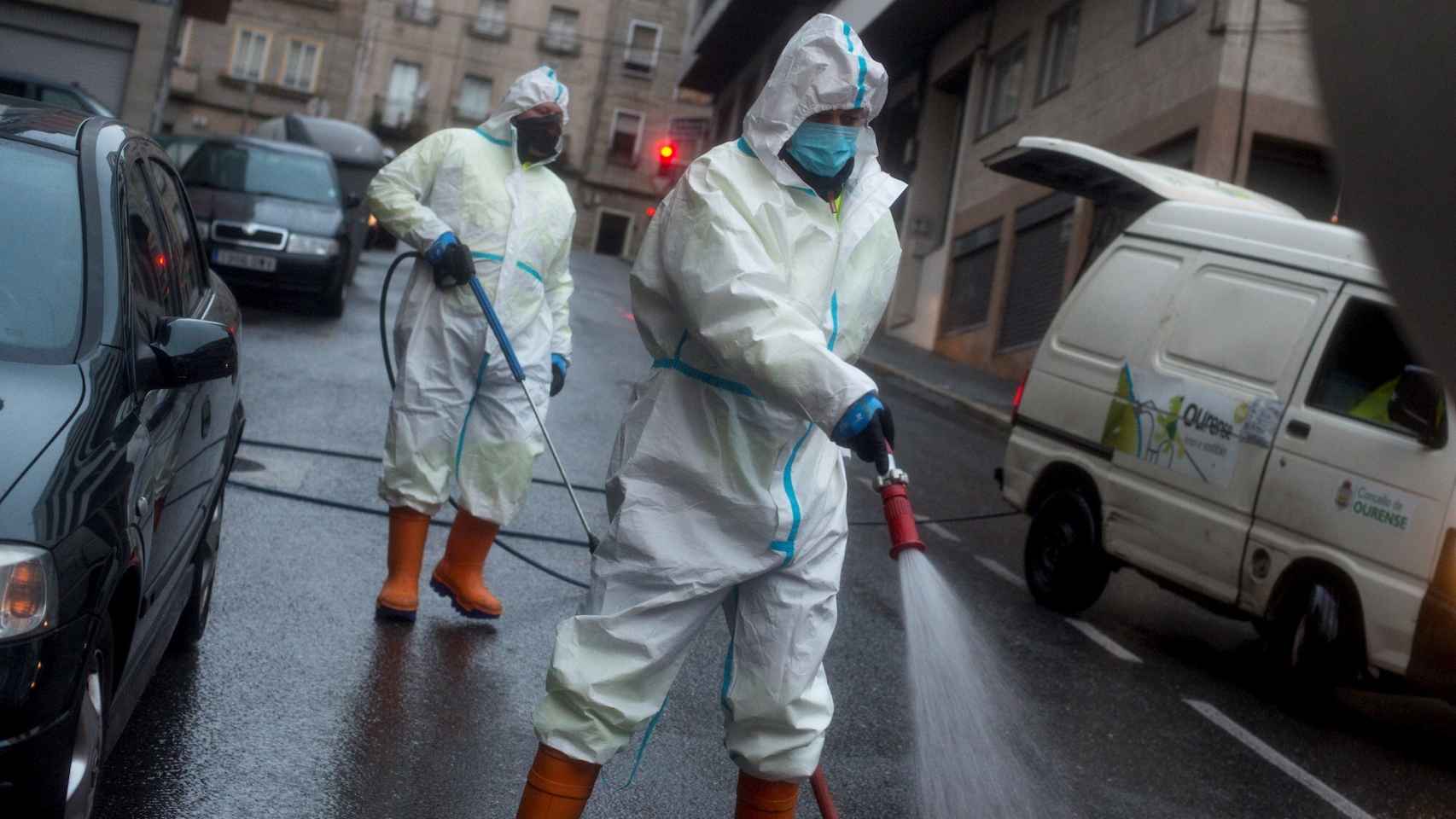 Operarios municipales realizan labores de desinfección en una calle de Orense.