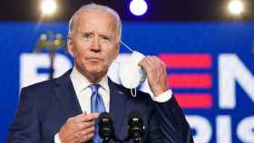 Joe Biden se quita la mascarilla antes de comenzar su rueda de prensa.