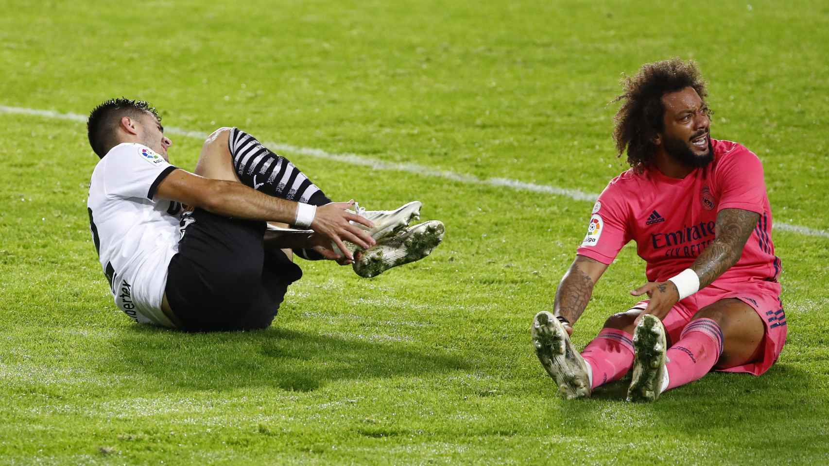 Maxi Gomez y Marcelo se duelen sobre el césped tras un encontronazo que acabó con un penalti a favor del Valencia