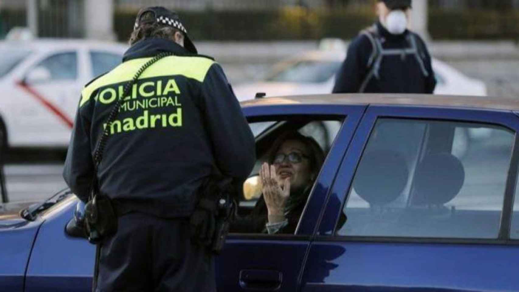 Un policía pone una multa de tráfico.