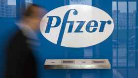 Un hombre pasa ante un logotipo de Pfizer.